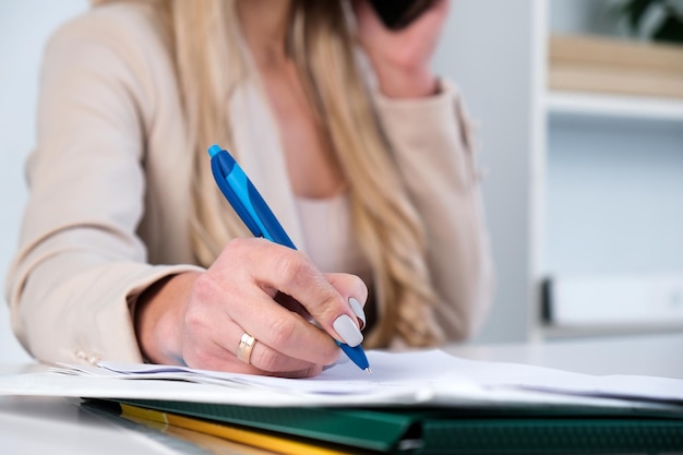 Business woman in business suit signing a document agreement contract being in her office Successful deal partnership investment or insurance deal filling document concept