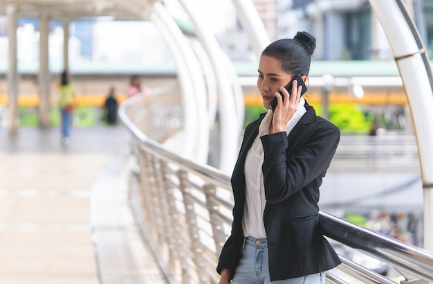 Business woman calling on mobile on outdoor walk way