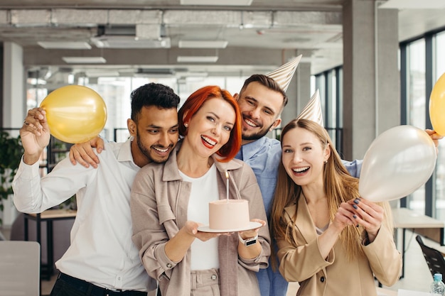 Business woman celebrating birthday and doing a party with colleagues in her office