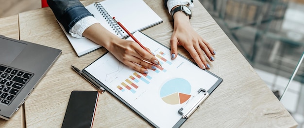 Business woman checks charts and refreshes financial progress The girl analyzes the business model in the workplace