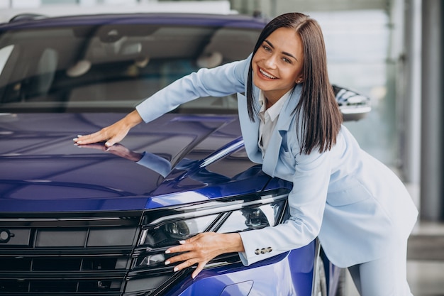 Business woman choosing a new car in a car showroom