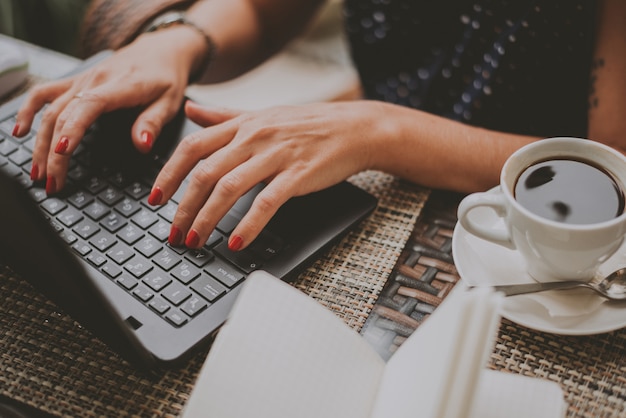 Business woman in coffee prints on a laptop close-up