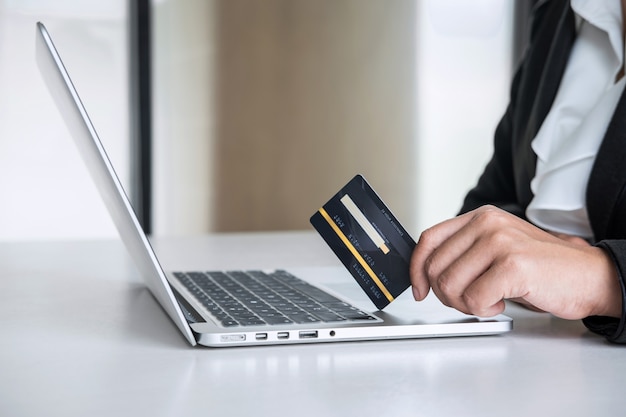 Business woman consumer holding credit card and typing on laptop for online shopping and payment make a purchase on the Internet, Online payment, networking and buy product technology