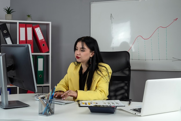 Business woman doing math finance or tax annual report with financial documents and laptop