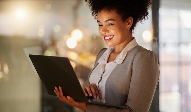 Business woman doing research on the internet with a laptop in a corporate modern office Working lady browsing website or reading a finance blog on a computer Happy female networking on technology