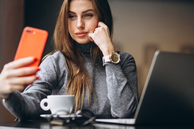 Business woman doing selfie in a cafe