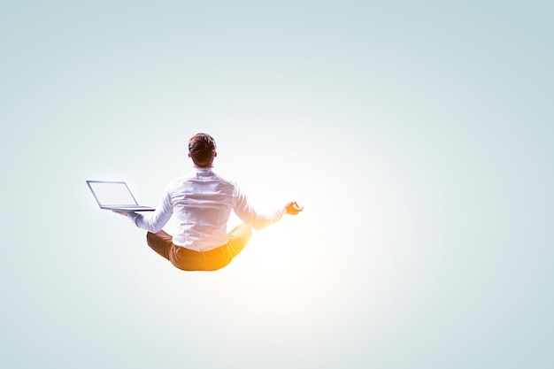 Business woman doing yoga in lotus pose