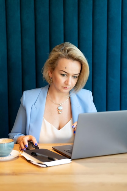 Business woman face beautiful caucasian young or mature professional career woman boss in business suit working on laptop modern women entrepreneur working in restaurant and cafe small business