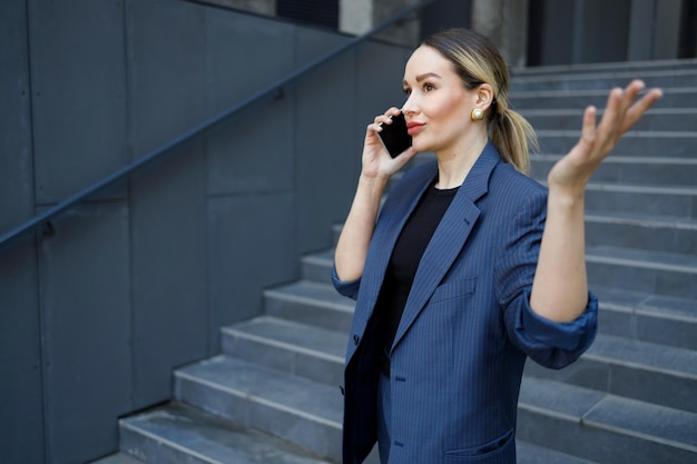 Business woman in formal wear talking on the phone outdoors