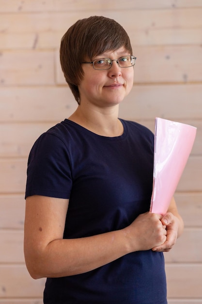 Business woman in glasses holding files and pen in