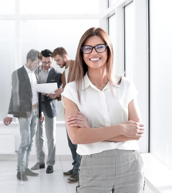 Business woman and a group of employees standing in the office