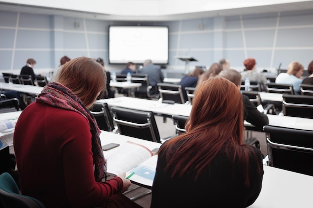 Business woman and group of people or students listen or look magazine textbook or advertising booklet to sonference presentation or lecture Horizontal Image