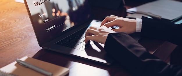 Business woman hands typing on laptop computer with sign up and password to online website