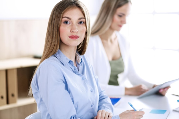 Business woman headshot. Businesspeople or colleagues discussing something at meeting while sitting at the desk in office. Casual clothes style. Audit, tax or lawyer concept.