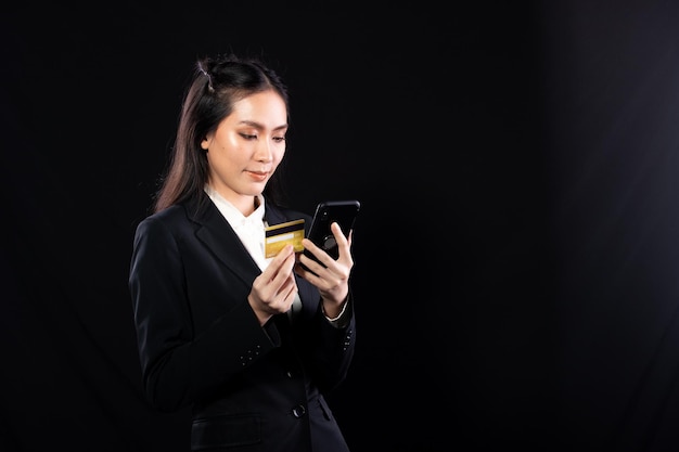 Business woman hold gold credit card and shopping online with internet financial banking payment when purchasing Technology help person shopping at home in ecommerce store on mobile phone or laptop