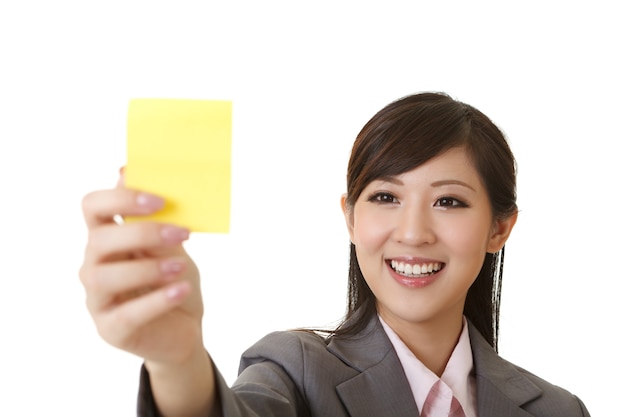 Business woman holding one yellow memo stick, closeup portrait on white.