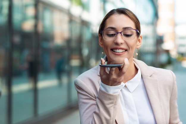 Business woman holding phone in hands and talking on phone close up