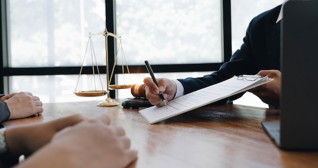 Business woman and lawyers discussing contract papers with brass scale on wooden desk in office Law legal services advice Justice concept