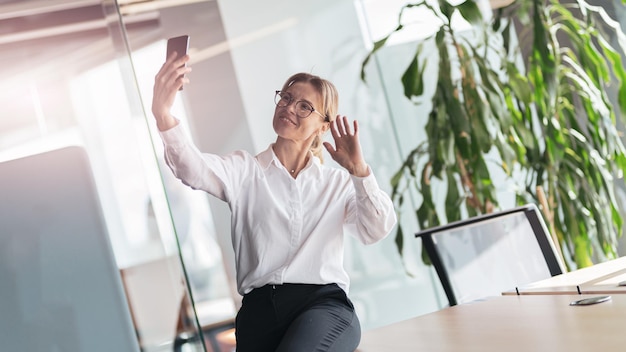 Business woman making video call to her colleague during break time