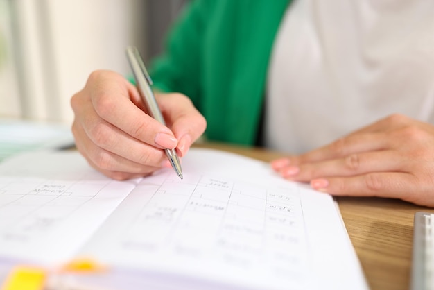 Business woman plans her business and takes notes in organizer at her desk in office