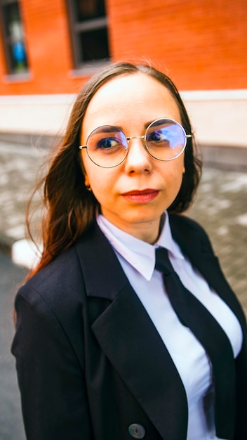 Business woman posing Young woman in glasses business suit on city street