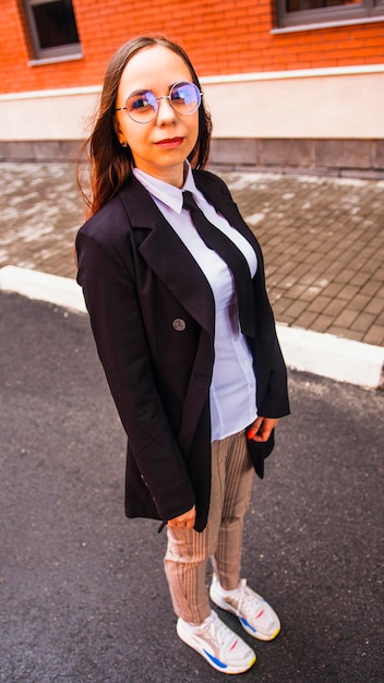 Business woman posing Young woman in glasses business suit on city street