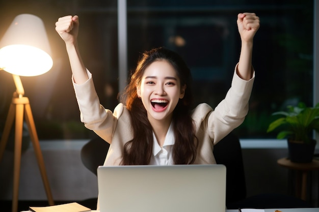 A business woman rejoicing in front of a computer