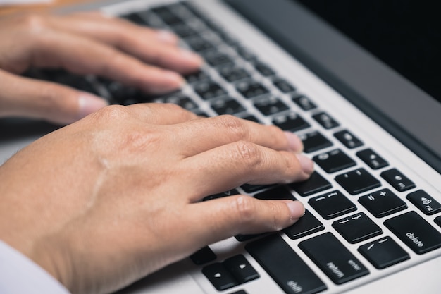 Business Woman’s hand typeing on laptop keyboard in the office workplace