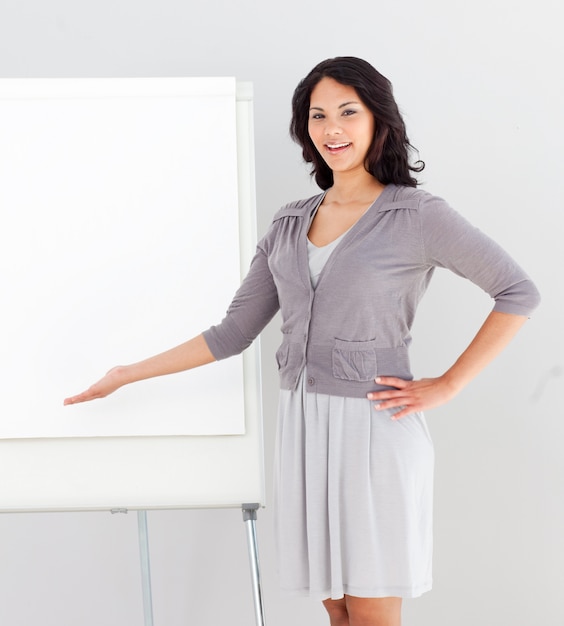 Business woman smiling and pointing at presentation Board