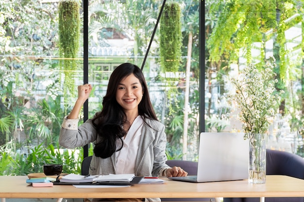 business woman smiling with arms up celebrating for success work at the office