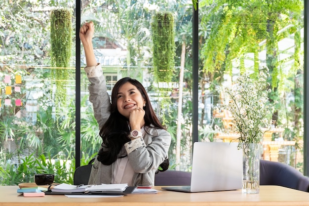 business woman smiling with arms up celebrating for success work at the office