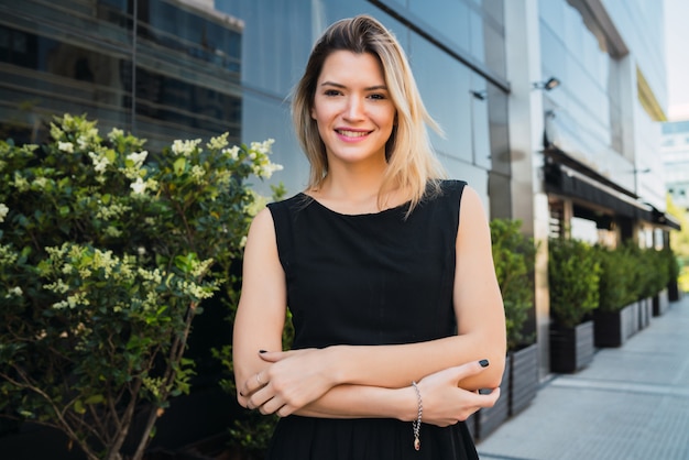 Business woman standing outside office buildings.