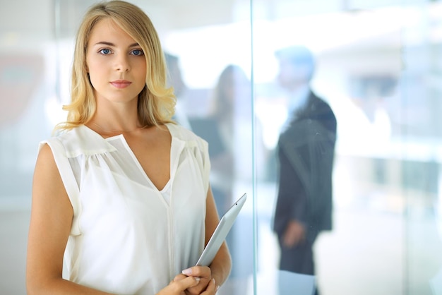 Business woman standing straight and smilling in office