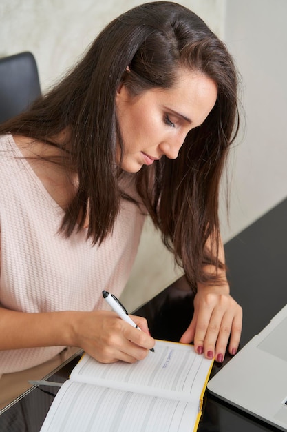 Business woman taking notes in desk