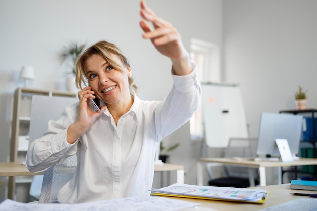 Business woman talking on the mobile phone asks to wait