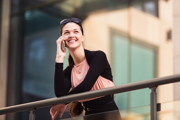 Business woman talking on the phone during a coffee break outside the office