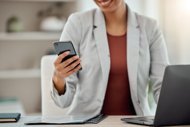 Business woman texting browsing and reading a notification on her phone while scrolling on social media in an office Entrepreneur checking messages apps and web while networking online at her desk