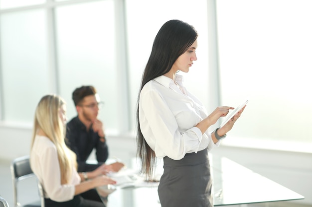 Business woman uses digital tablet while standing near office Desk .people and technology