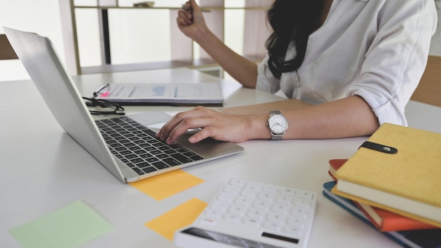 Business woman using laptop to search for information while working from home.