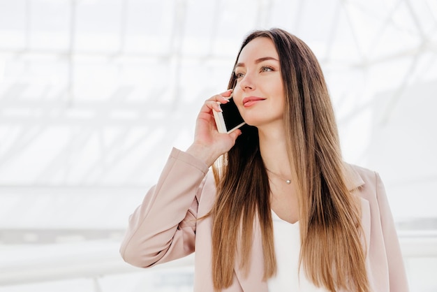 Business woman using phone and talking in the office building