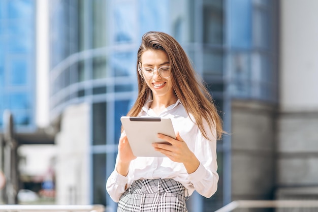 Business woman using tablet near modern business center.