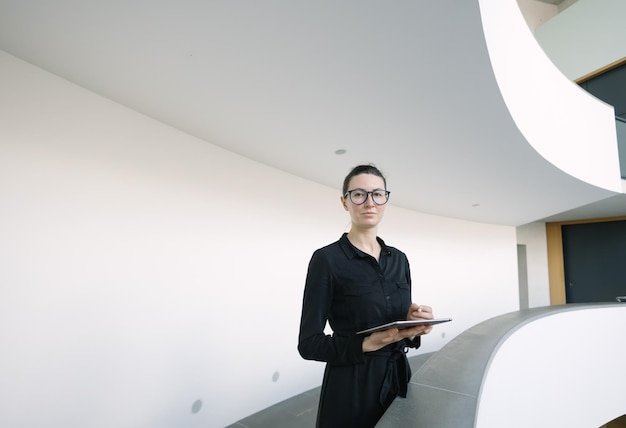 Business woman using tablet pc in minimalist office interior