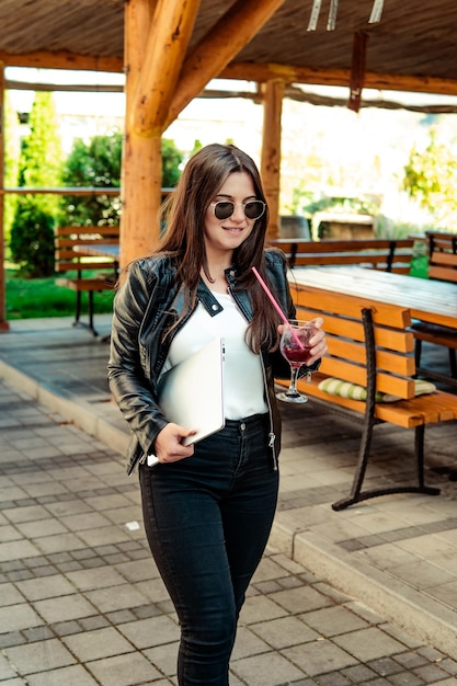 Business woman walking on the street carrying a laptop computer