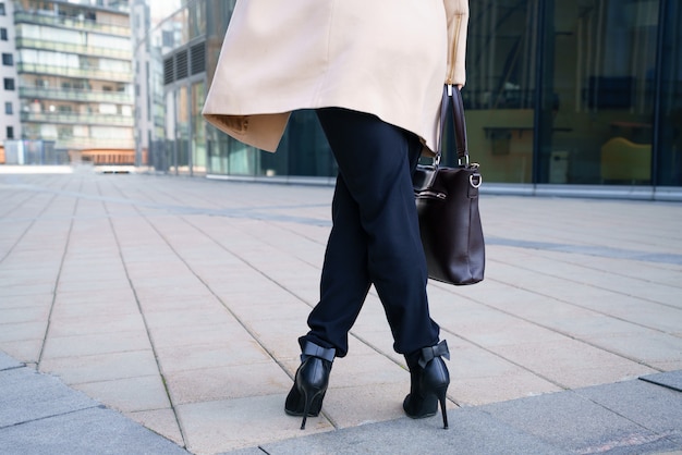 A business woman walks to the business center in heels. Conceptual horizontal photo without a face