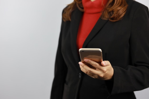 Business woman wearing black and red business suit uniform holding and looking mobile phone with confident   