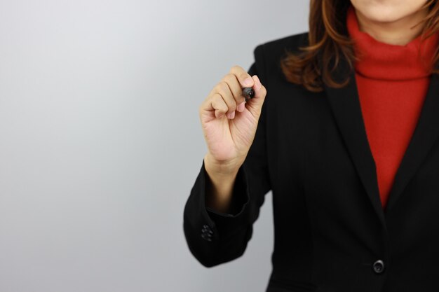 Business woman wearing black and red business suit uniform holding pen and drawing something with confident