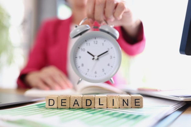 Photo business woman with alarm clock in hand and text deadline on cubes time management techniques