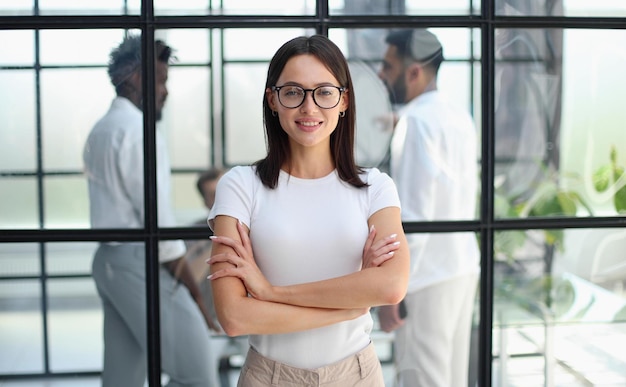 Business woman with her staff in background at office