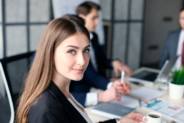 Business woman with her staff, people group in background at modern bright office indoors