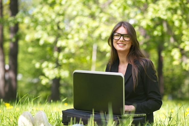 Business woman with laptop in park